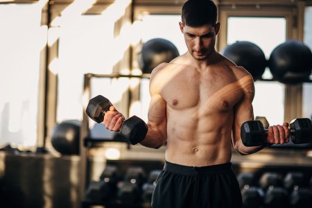 muscular-shirtless-man-exercising-with-dumbbells-royalty-free-image-1711991944.jpg